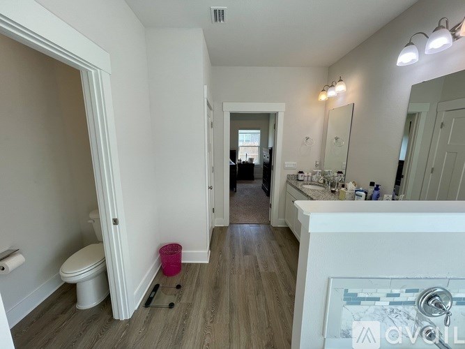 A bathroom with a toilet, sink, and mirror.