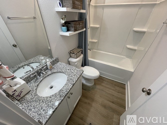 A bathroom with a granite countertop and a white toilet.