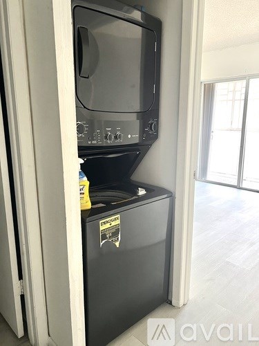 A black oven with a sticker on it is in a room with a white door.