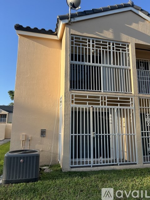 A house with a satellite dish on the roof and a gate with bars.