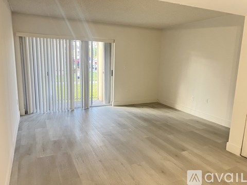 A room with a sliding glass door leading to a parking lot.