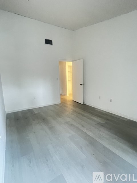 A room with a wooden floor and a white door.
