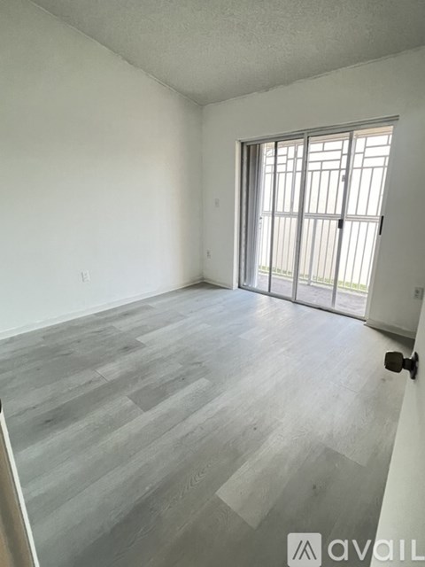 A room with a sliding door and wooden flooring.