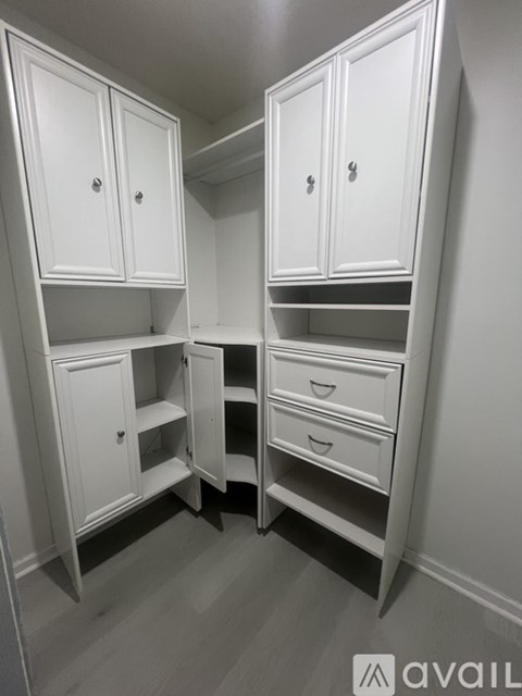 A white cabinet with drawers is open.