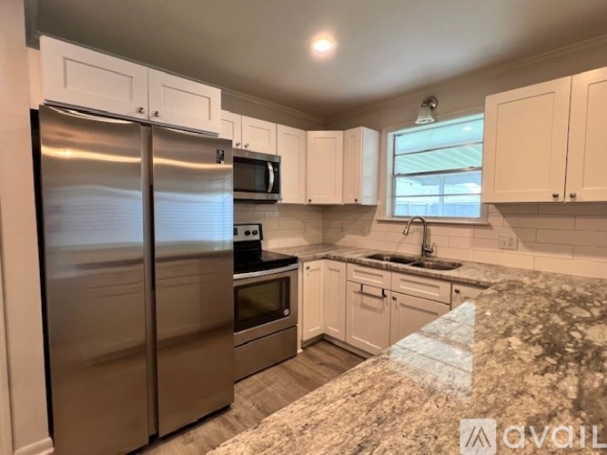 A kitchen with a granite countertop and stainless steel appliances.