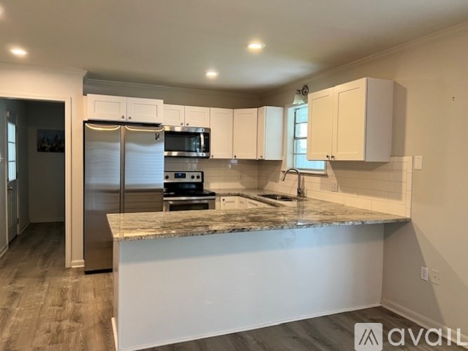 A kitchen with a granite countertop and stainless steel appliances.
