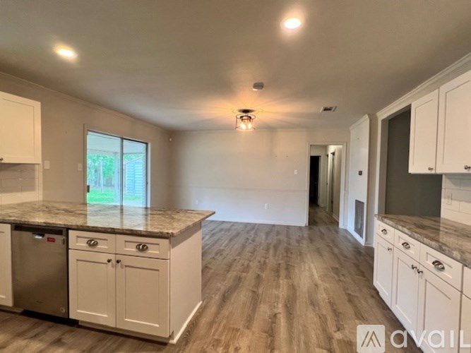 A kitchen with white cabinets and a granite countertop.