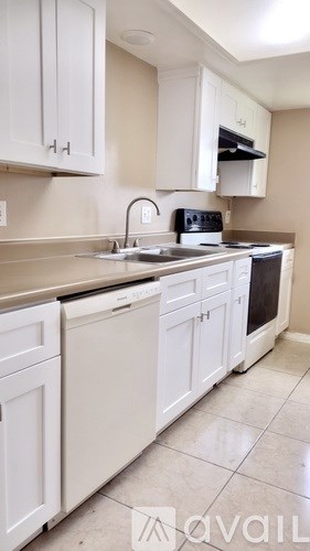A kitchen with white cabinets and appliances.