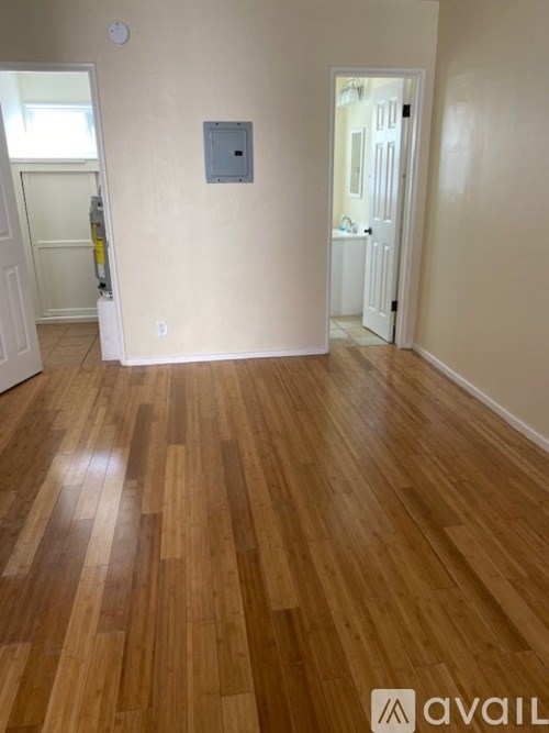A room with wooden flooring and a white door.
