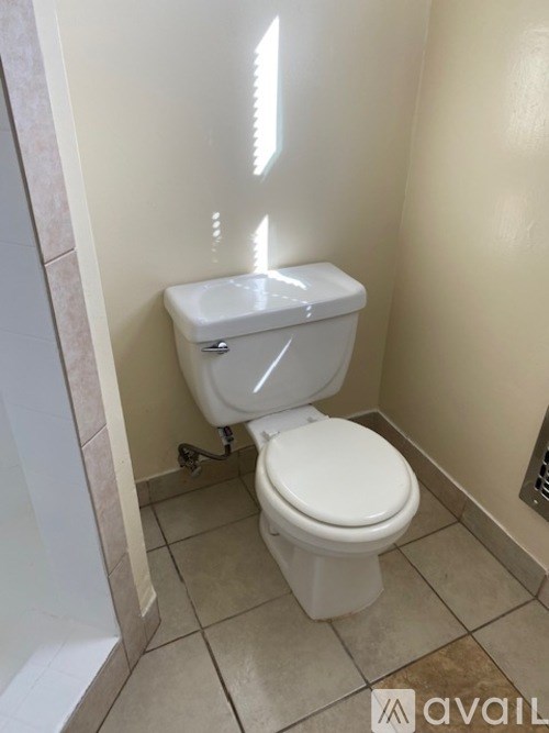 A white toilet in a small bathroom.