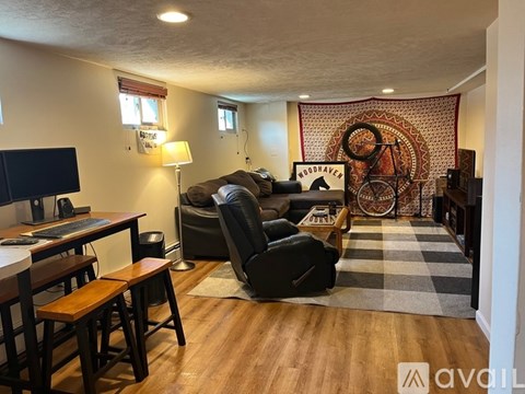 A living room with a black leather chair and a wooden table.
