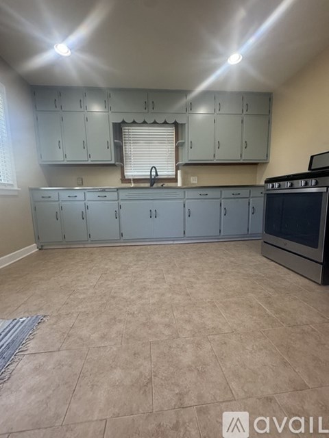 A kitchen with a tile floor and a stove top oven.