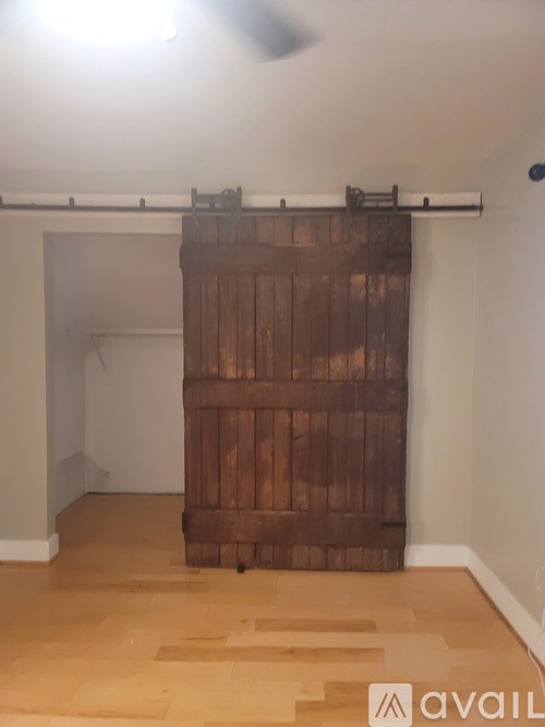 A room with a wooden door and a fan on the ceiling.