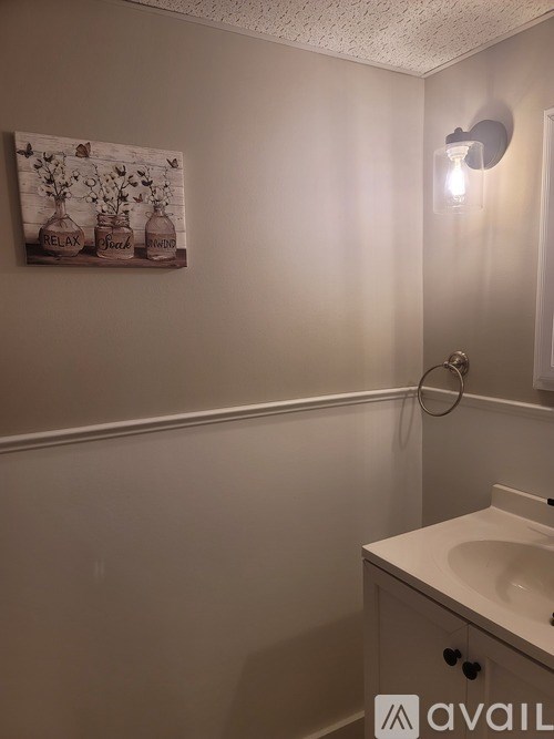 A bathroom with a white sink and a poster on the wall.