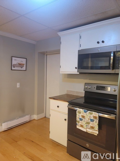 A kitchen with a black oven and white cabinets.