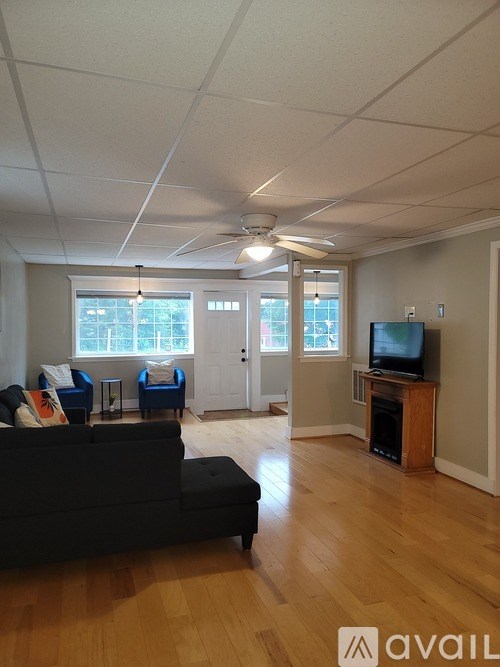 A living room with a black couch and a television.