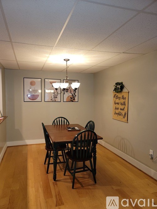 A dining room with a wooden table and chairs.