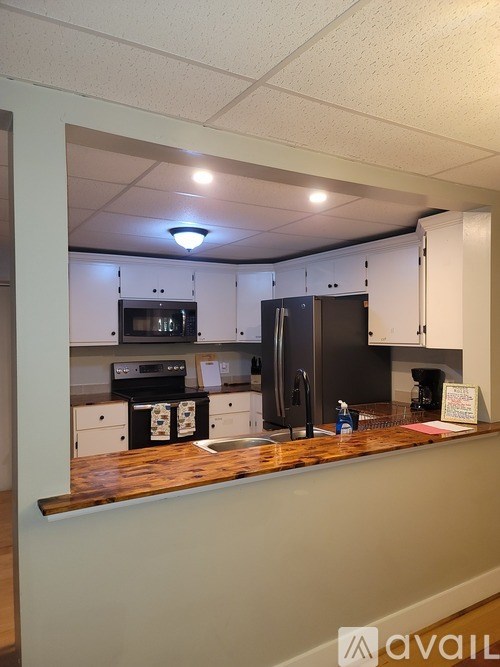 A kitchen with a refrigerator, oven, and microwave.
