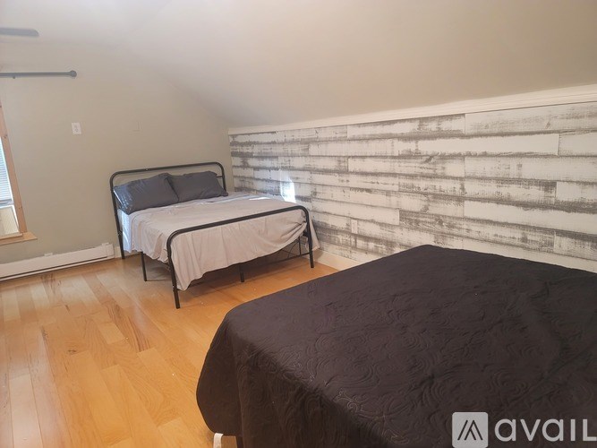 A bedroom with two beds and a wooden floor.