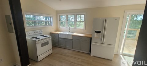 A kitchen with a white stove top oven and a white fridge.