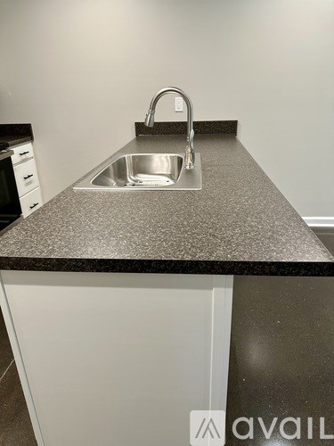 A kitchen counter with a sink and a faucet.