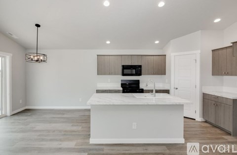 A modern kitchen with a white island and wooden cabinets.