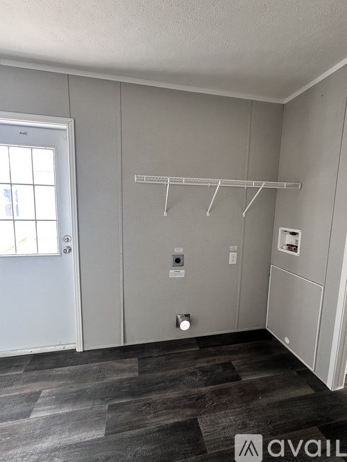 A room with a grey wall and a white door.