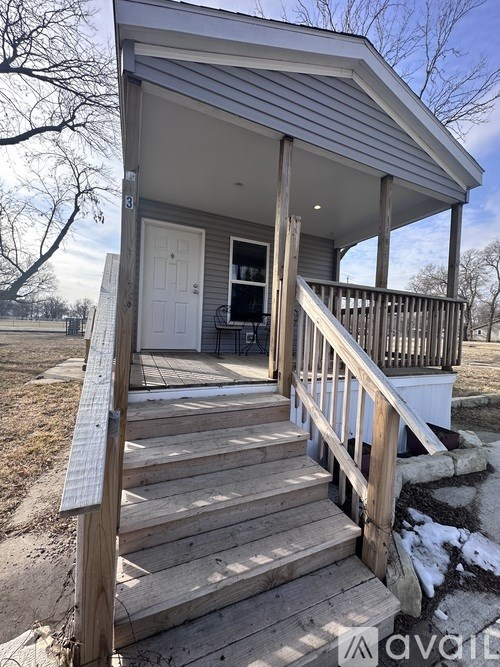 A small house with a porch and a white door.