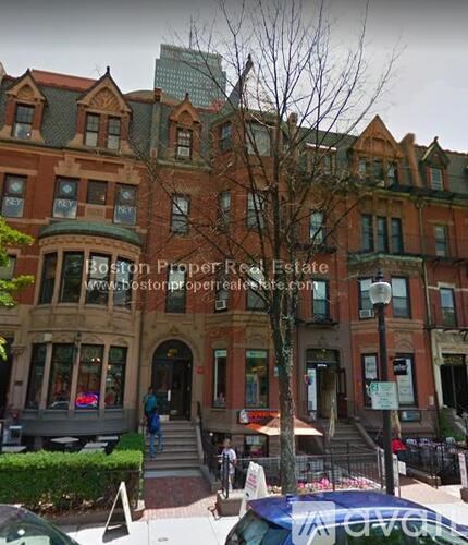 A street view of a building with the text "Boston Proper Real Estate" on it.