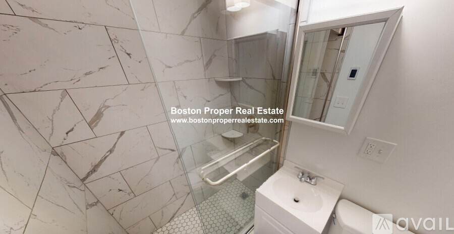 A marble bathroom with a walk-in shower and a toilet.