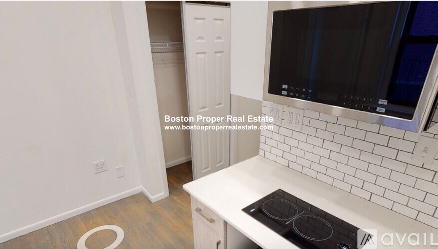 A kitchen with a white countertop and a black stove top oven.