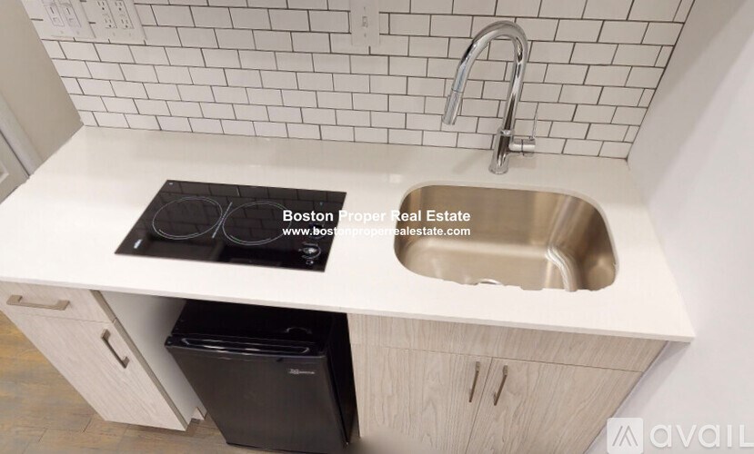 A kitchen counter with a stove top and sink.