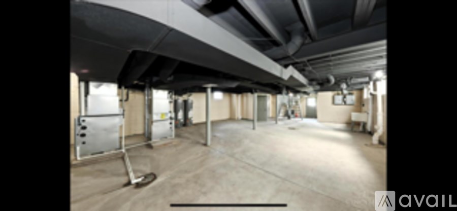 A large, empty warehouse space with a high ceiling and concrete floors.