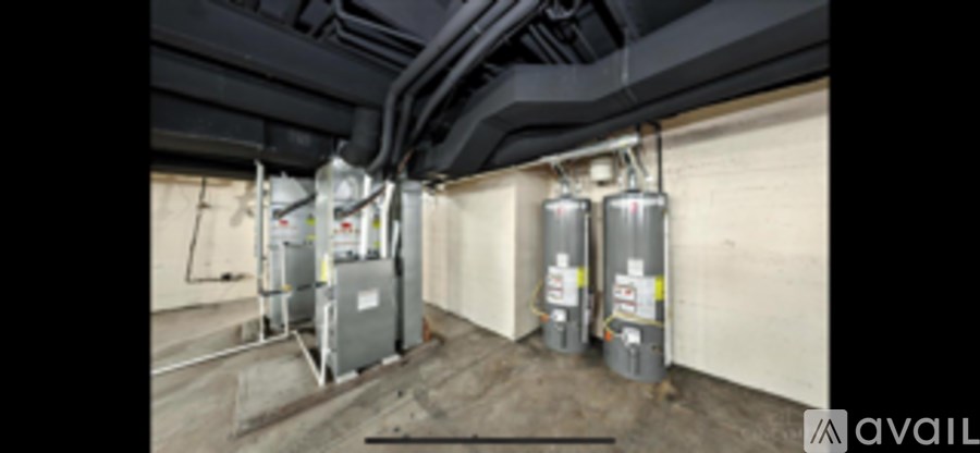 A room with a wall of pipes and a wall of tanks.