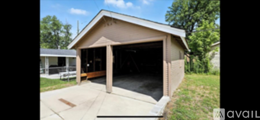 A detached garage with a covered entrance and a concrete driveway.