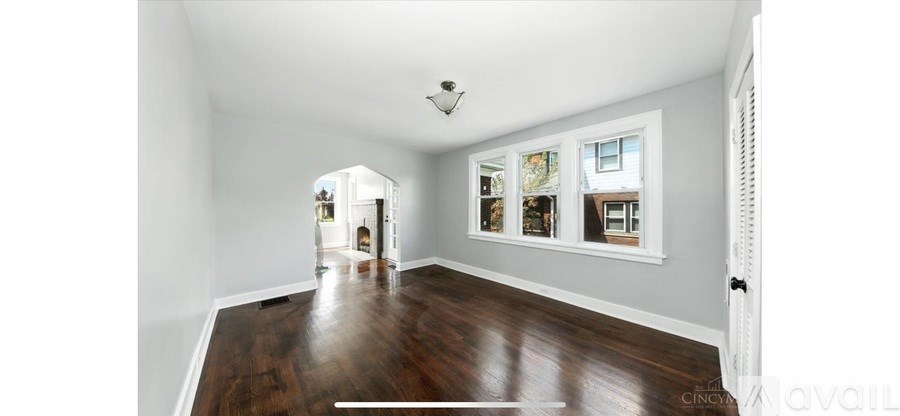 A spacious room with wood flooring and a white ceiling.