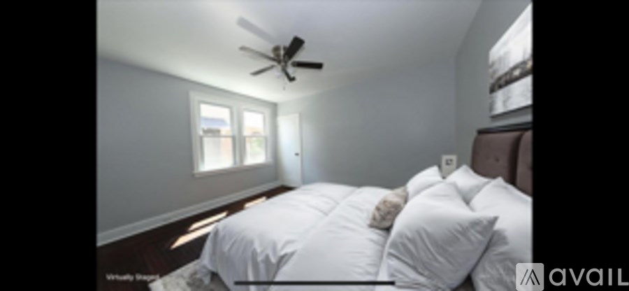 A bedroom with a bed, pillows, and a ceiling fan.