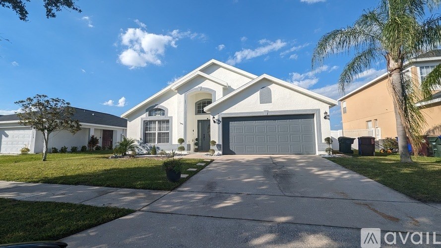 A large, two-story house with a driveway in front.