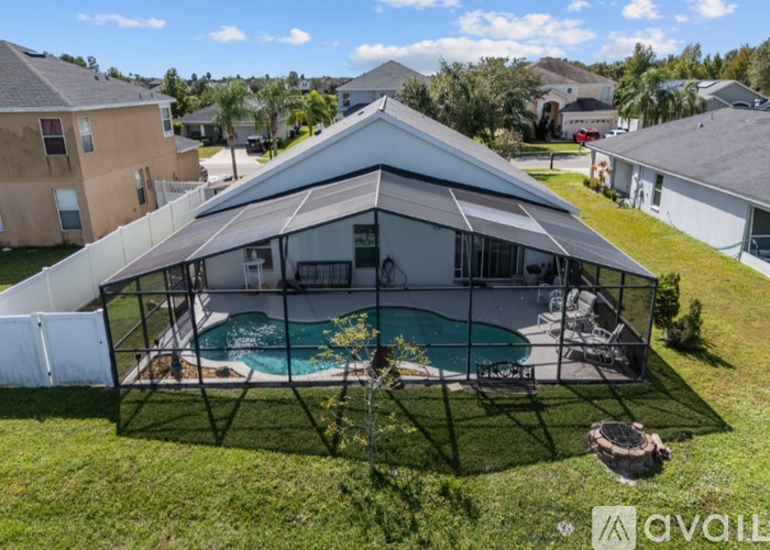 A large white tent with a pool in the middle of a grassy area.