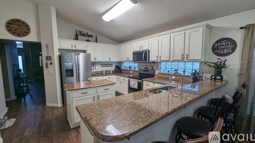 A kitchen with granite countertops and white cabinets.