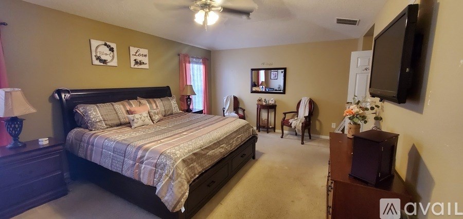 A bedroom with a large bed and a flat screen TV mounted on the wall.