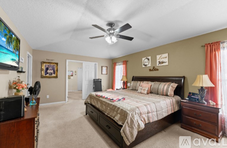 A bedroom with a bed, dresser, and television.