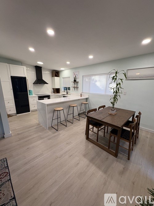 A modern kitchen with a dining table and chairs.