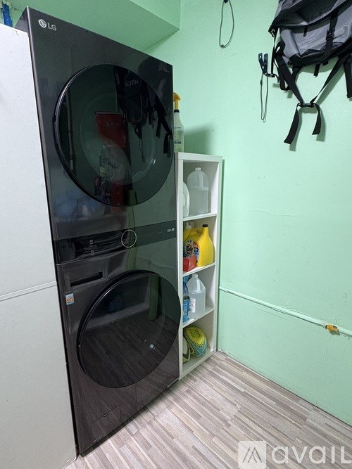 A black LG front loading washing machine in a laundry room.