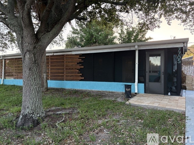 A modern house with a tree in front.