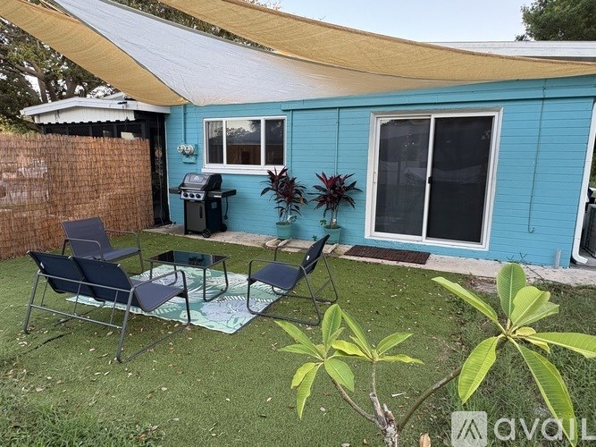 A blue house with a patio and chairs.