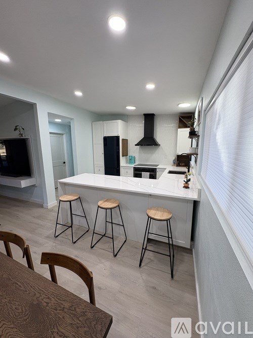 A kitchen with a bar area and stools.