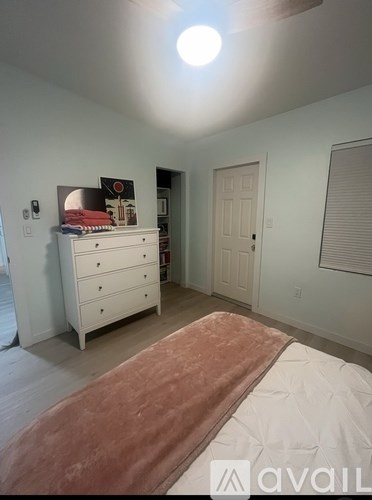 A bedroom with a bed, dresser, and mirror.