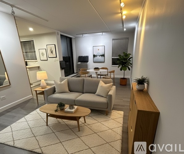 A living room with a grey sofa, a wooden coffee table, and a white rug.