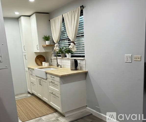 A kitchen with white cabinets and a wooden countertop.